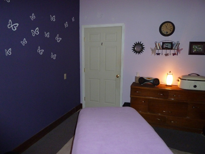 The real lavender treatment room at Chichester Massage, with a prepared table and warm lamplight