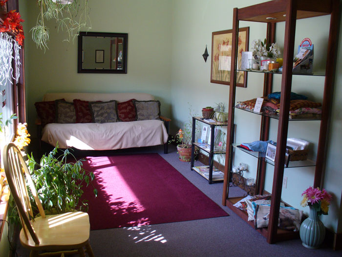 The center’s actual welcoming waiting room with a sofa, plants and purple rug